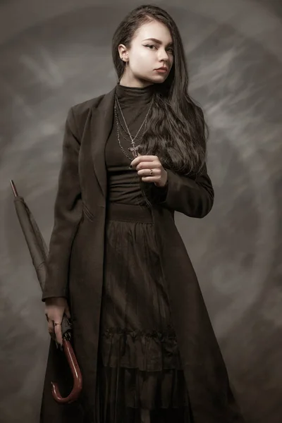Siyah saçlı, siyah, klasik tarzda genç bir kız. Gotik elementlerle