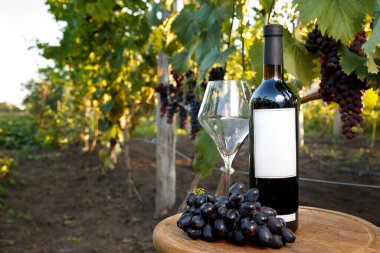 Ahşap arka planda bir şişe şarap ve bir bardak şarap