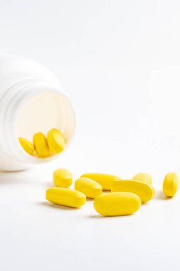  Beyaz arka planda izole edilmiş sarı haplar ve şişe