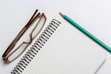 beyaz arkaplanda dizüstü bilgisayar, kalem ve gözlük izole edildi