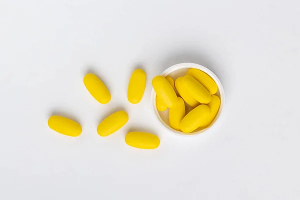 Beyaz arka planda izole edilmiş sarı haplar