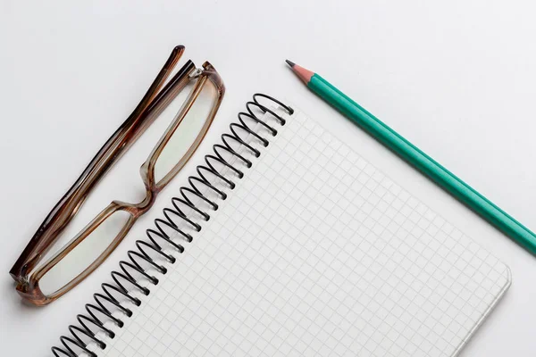 beyaz arkaplanda dizüstü bilgisayar, kalem ve gözlük izole edildi