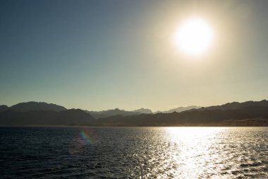 Mısır dağları kızıl denizden görünüyor. Gün batımında dağların manzarası