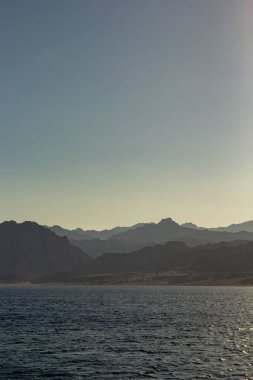 Mısır dağları kızıl denizden görünüyor. Gün batımında dağların manzarası