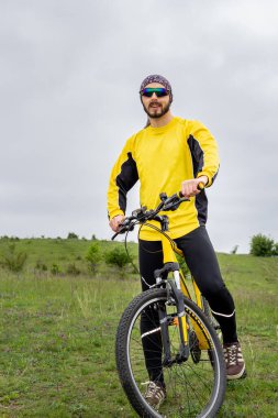 Bir bisikletçi bisiklete biner ve uzaklığa bakar.