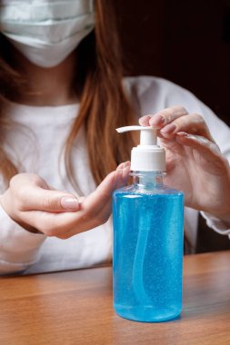 Kadın alkol jeli ya da antibakteriyel sabun dezenfektanı sıkar. Pompa şişesinde mikropları, bakterileri ve virüsü öldürmek için dezenfekte edilir..