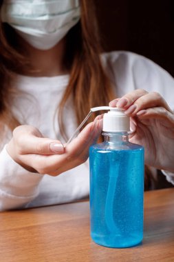 Kadın alkol jeli ya da antibakteriyel sabun dezenfektanı sıkar. Pompa şişesinde mikropları, bakterileri ve virüsü öldürmek için dezenfekte edilir..