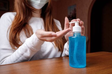 Kadın alkol jeli ya da antibakteriyel sabun dezenfektanı sıkar. Pompa şişesinde mikropları, bakterileri ve virüsü öldürmek için dezenfekte edilir..