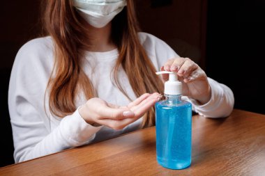 Kadın alkol jeli ya da antibakteriyel sabun dezenfektanı sıkar. Pompa şişesinde mikropları, bakterileri ve virüsü öldürmek için dezenfekte edilir..