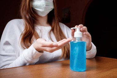 Kadın alkol jeli ya da antibakteriyel sabun dezenfektanı sıkar. Pompa şişesinde mikropları, bakterileri ve virüsü öldürmek için dezenfekte edilir..