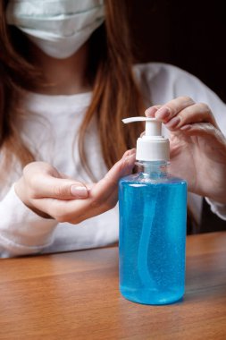 Kadın alkol jeli ya da antibakteriyel sabun dezenfektanı sıkar. Pompa şişesinde mikropları, bakterileri ve virüsü öldürmek için dezenfekte edilir..