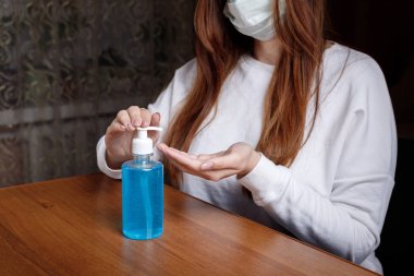 Kadın alkol jeli ya da antibakteriyel sabun dezenfektanı sıkar. Pompa şişesinde mikropları, bakterileri ve virüsü öldürmek için dezenfekte edilir..