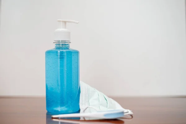 antiseptic, medical face mask and electronic thermometer on the table. sanitizer gel to wash hands for flu virus prevention