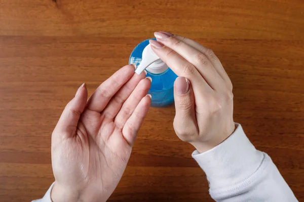 Kadın alkol jeli ya da antibakteriyel sabun dezenfektanı sıkar. Pompa şişesinde mikropları, bakterileri ve virüsü öldürmek için dezenfekte edilir..