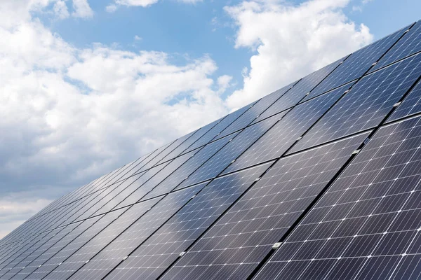Mavi gökyüzünün arkaplanındaki güneş panellerinin yakın görüntüsü