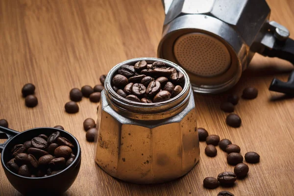Kahve çekirdekleri kahve makinesinde ve ahşap bir masada.