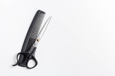 Beyaz arka planda makas ve tarak. Metin için yer