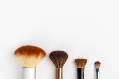 Beyaz arka planda farklı boyutlarda makyaj fırçaları