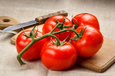 Kesme tahtasında sulu kırmızı domatesler ve bıçak