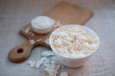 Kumaş bir masa örtüsü üzerinde bir kasede hindistan cevizi cipsi ve talaş.