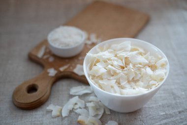 Kumaş bir masa örtüsü üzerinde bir kasede hindistan cevizi cipsi ve talaş.