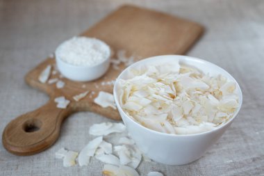 Kumaş bir masa örtüsü üzerinde bir kasede hindistan cevizi cipsi ve talaş.