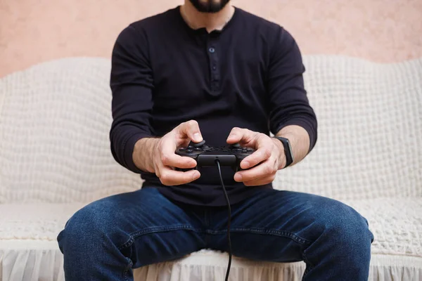  Bir adam elinde kumandayla oyun oynuyor.