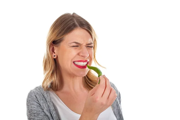 Beautiful girl biting of a hot paprika — Stock Photo, Image