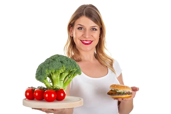 Chica feliz sosteniendo hamburguesa y verduras frescas — Foto de Stock