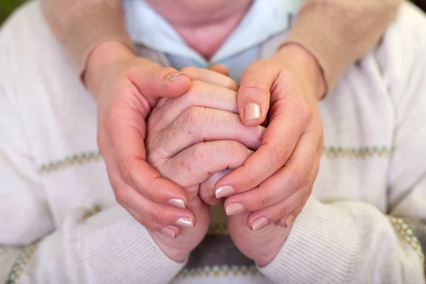 Postarší ruce & rukou mladého pečovatele — Stock fotografie