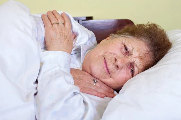 Sick old lady in bed — Stock Photo, Image