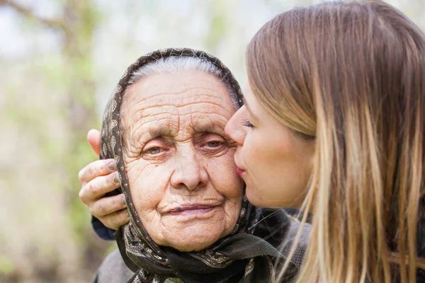 Jeune femme embrassant sa grand-mère malade — Photo