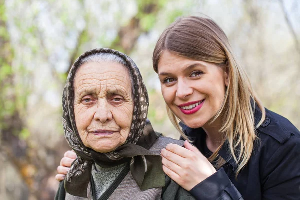 Enferma anciana con su cuidador al aire libre — Foto de Stock