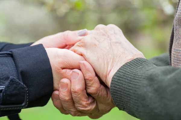 Senior & jonge vrouw hand in hand — Stockfoto