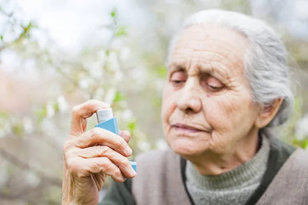 Ältere Frau mit Asthmaanfall, hält Bronchodilatator in der Hand — Stockfoto