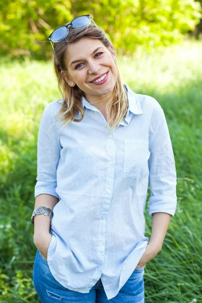 Mulher sorridente elegante em um prado verde — Fotografia de Stock