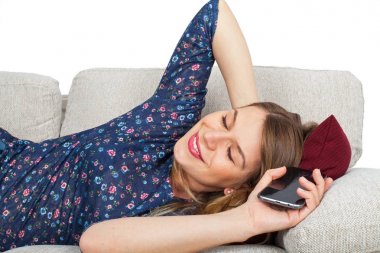 Telefonunu tutan baştan çıkarıcı kadın kanepede,