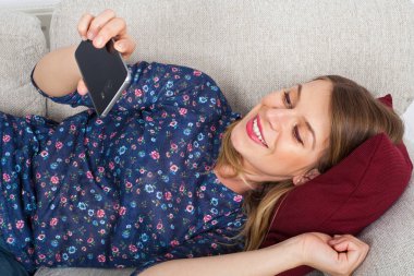 Görüntülü sohbet sahip kadın kanepede yalan