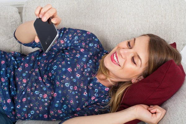 Görüntülü sohbet sahip kadın kanepede yalan