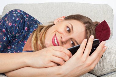 Telefonunu tutan baştan çıkarıcı kadın kanepede,