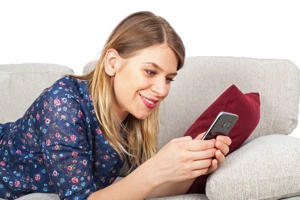 Mujer teniendo un video chat, acostada en el sofá — Foto de Stock