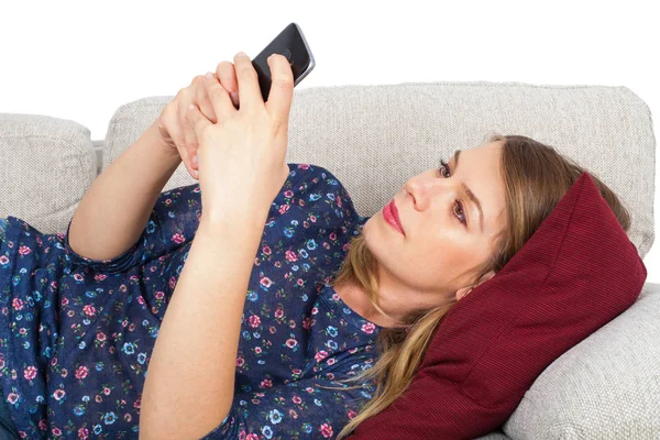 Mujer teniendo un video chat, acostada en el sofá — Foto de Stock
