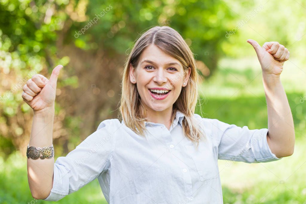 Gorgeous young lady showing thumbs up