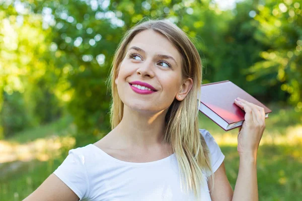 Beautiful female student holding a book — Stock Photo, Image