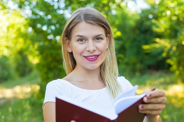 Beautiful female student holding a book — Stock Photo, Image