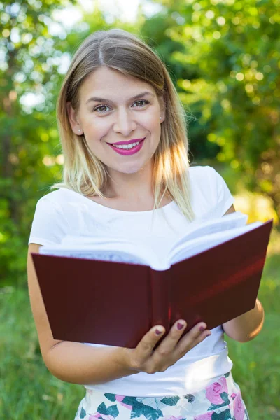 Beautiful female student holding a book — Stock Photo, Image