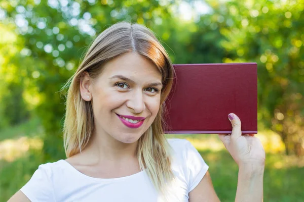 Beautiful female student holding a book — Stock Photo, Image