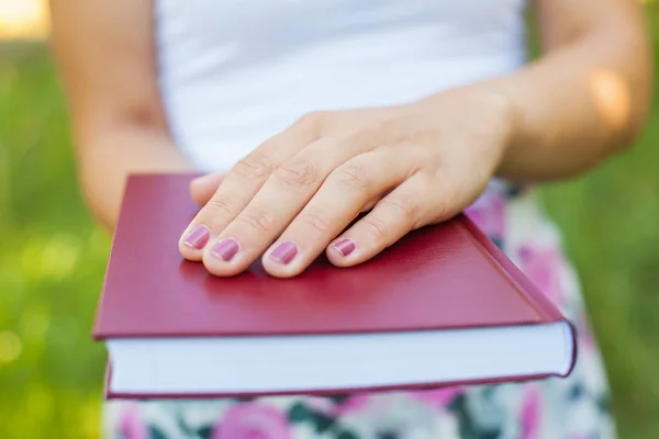 Close up female hands holding a book — Stock Photo, Image