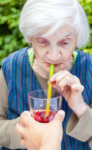 Ahududu suyu içme alzheimer hastalığı olan yaşlı kadın — Stok fotoğraf