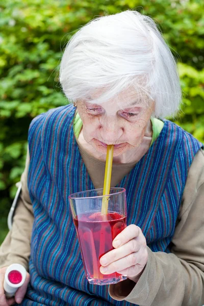 アルツハイマー病のラズベリー ジュースを飲む老婦人 — ストック写真